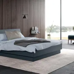 Une chambre grise moderne avec un grand lit, une vue sur l'eau et un mur en bois sombre.