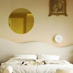 Un chat dort sur un lit douillet. Le beige va avec le blanc, le bois et les touches dorées, créant une ambiance chaleureuse.