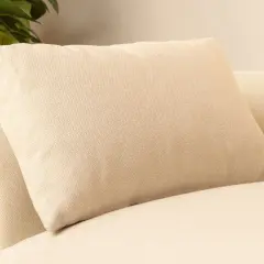 Un coussin beige texturé, de taille parfaite pour un canapé confortable, avec un logo "Marque Française" discret.