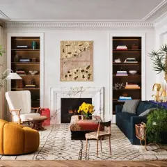 Un salon élégant où un **mixer moderne et ancien** se révèle dans le mobilier éclectique, les étagères remplies et l'art mural texturé.