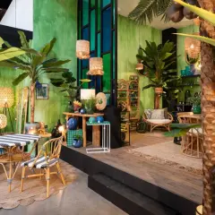 Un salon jungle chic avec des plantes luxuriantes, des meubles en rotin et des touches de bleu et d'or.