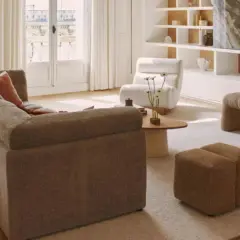 Un salon lumineux avec un canapé modulable, des fauteuils confortables et une banquette design. Un **intérieur contemporain chaleureux** invitant à la détente.