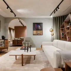 Salon lumineux avec canapé blanc, étagère en bois design et tableau abstrait. Une ambiance de deco maison moderne chic.