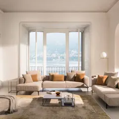 Salon lumineux avec canapé modulable, pouf et tapis doux pour une deco appartement cocooning parfaite. Vue sur lac et ville.