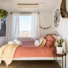Une chambre d'amis polyvalente avec un lit confortable, des plantes vertes et une vue désertique.