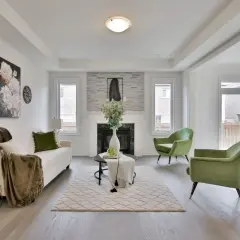 Salon moderne avec canapé blanc, fauteuils verts et cheminée. Une belle idée déco moderne pour un intérieur lumineux.