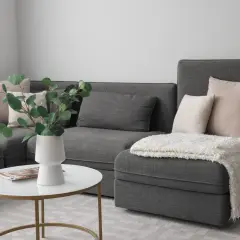 Comment disposer des coussins sur un canapé d'angle : des coussins roses et gris créent un look cosy.
