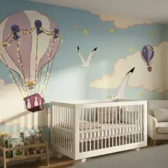 Aménagement chambre bébé avec mur décoré de montgolfières et d'oiseaux. Un berceau blanc, un fauteuil confortable et une étagère à livres complètent la pièce.
