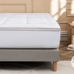 Un surmatelas blanc moelleux sur un sommier gris. Idéal si votre matelas est trop dur que faire ? Fabrication française.