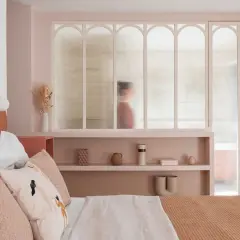 Idées pour comment décorer sa chambre : une chambre douce aux tons pastel, avec une tête de lit originale et des étagères décorées.