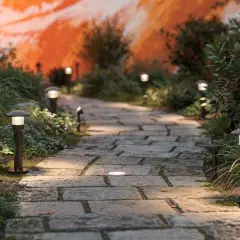 Allée pavée illuminée par des bornes discrètes, créant un éclairage d'allée carrossable chaleureux et sécurisant.