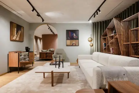 Salon lumineux avec canapé blanc, étagère en bois design et tableau abstrait. Une ambiance de deco maison moderne chic.