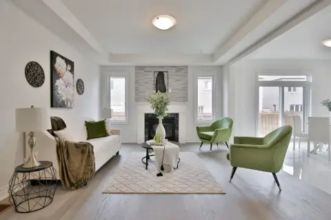 Salon moderne avec canapé blanc, fauteuils verts et cheminée. Une belle idée déco moderne pour un intérieur lumineux.