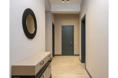 Un couloir sans fenêtre peut être lumineux avec des murs clairs et un grand miroir. Les portes sombres créent un contraste élégant.