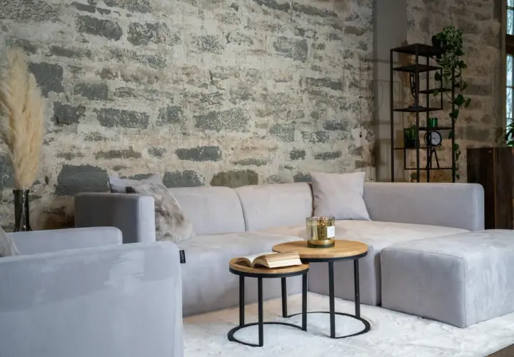 Un salon cosy avec un canapé gris clair sur un tapis blanc. Une question se pose : quelle couleur de tapis irait le mieux avec un canapé gris ?