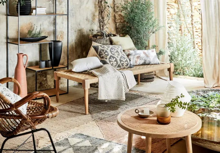 Un canapé moche en corde tressée, orné de coussins décoratifs, dans un salon bohème avec des plantes et une lumière douce.