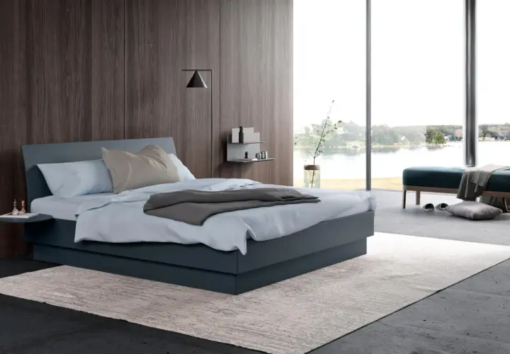 Une chambre grise moderne avec un grand lit, une vue sur l'eau et un mur en bois sombre.