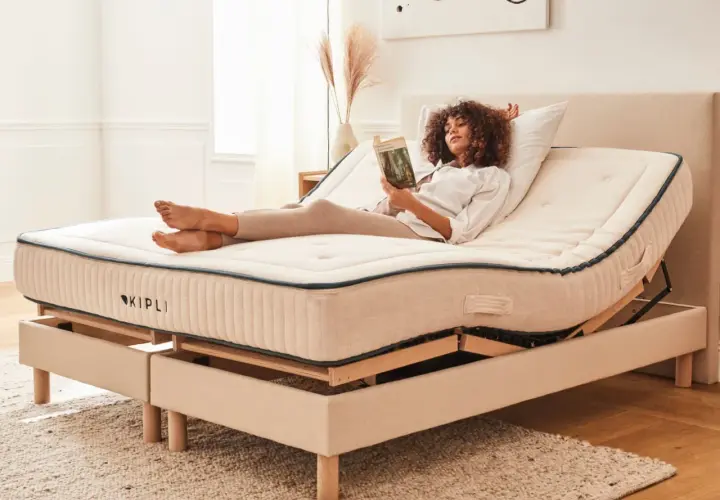 Femme lisant sur un lit électrique réglable. Avantage inconvénient lit électrique : confort personnalisé pour la détente.