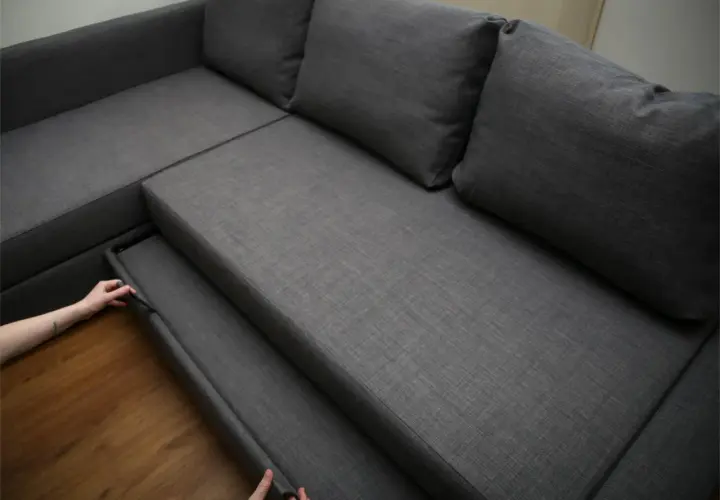 Maintenant, découvrez comment démonter un canapé relax. Une main tire sur une partie du siège pour commencer le désassemblage.