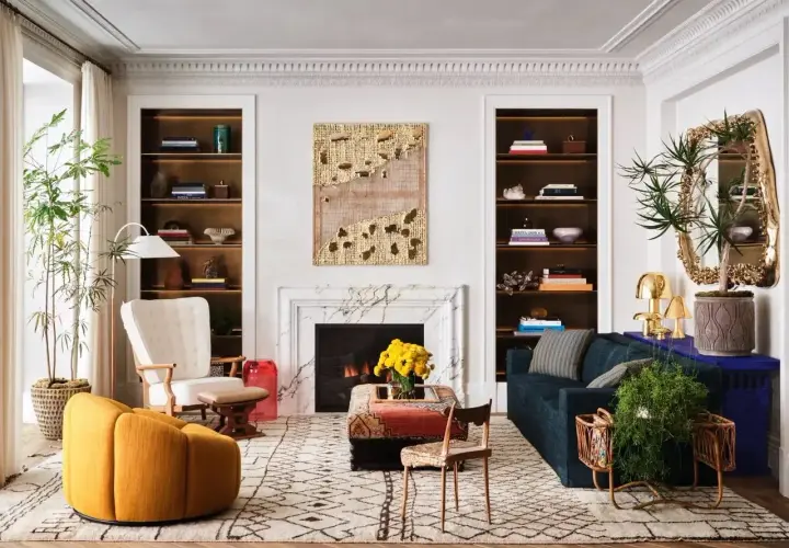 Un salon élégant où un **mixer moderne et ancien** se révèle dans le mobilier éclectique, les étagères remplies et l'art mural texturé.