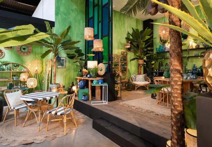 Un salon jungle chic avec des plantes luxuriantes, des meubles en rotin et des touches de bleu et d'or.