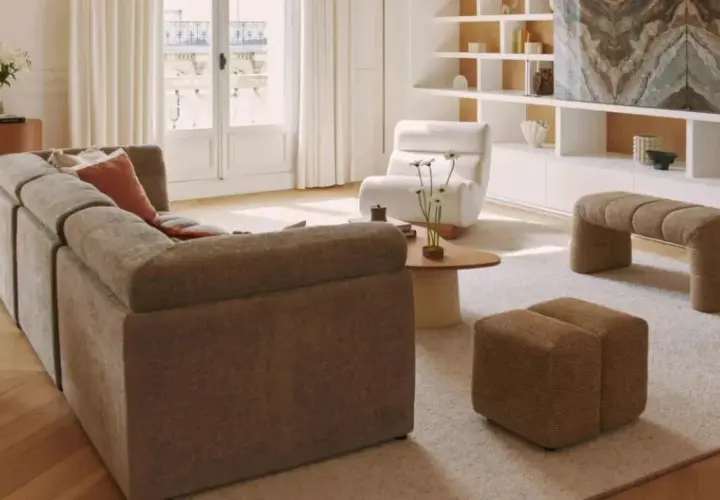 Un salon lumineux avec un canapé modulable, des fauteuils confortables et une banquette design. Un **intérieur contemporain chaleureux** invitant à la détente.