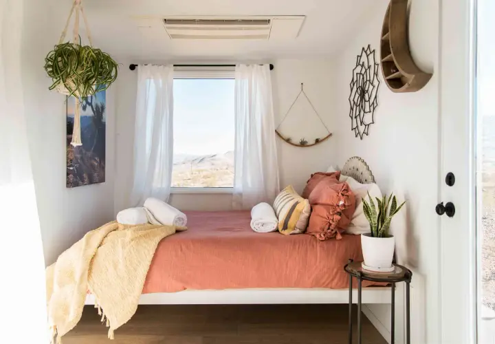 Une chambre d'amis polyvalente avec un lit confortable, des plantes vertes et une vue désertique.