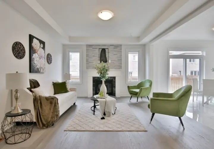 Salon moderne avec canapé blanc, fauteuils verts et cheminée. Une belle idée déco moderne pour un intérieur lumineux.