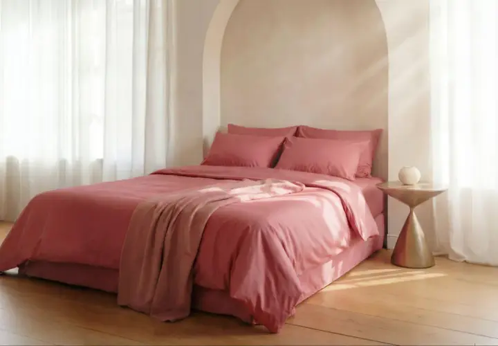 Lit rose avec couvre-lit et coussins. Le polycoton, malgré son aspect doux, peut avoir un inconvénient : il retient la chaleur.