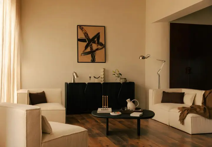 Salon moderne avec fauteuils blancs, buffet noir, tableau abstrait et table basse. Une ambiance chaleureuse pour une deco interieur tendance.
