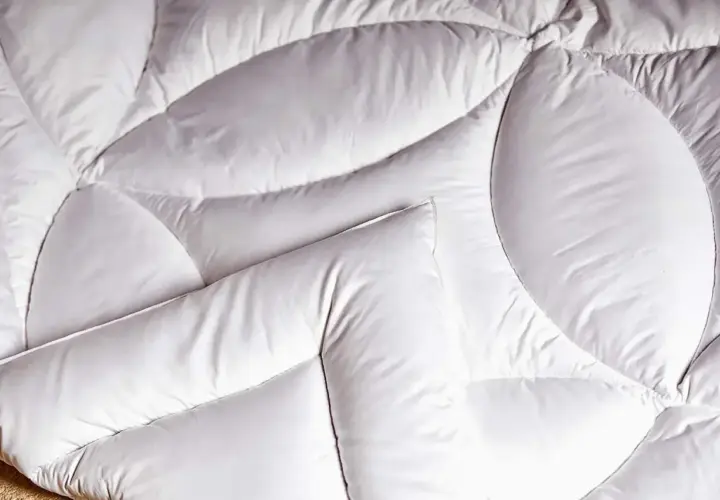 Un édredon blanc, doux et matelassé, prêt à vous envelopper de chaleur. C'est quoi un édredon ? C'est ce confort douillet.