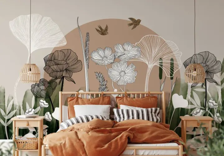 Une chambre romantique moderne avec une fresque murale botanique. Le lit est paré de linge de lit ocre et de coussins rayés.