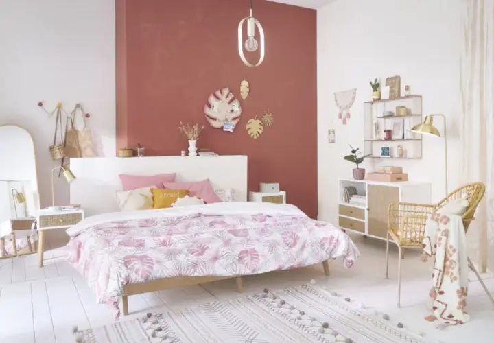 Chambre rose et vert adulte, avec un lit douillet, des touches végétales et une décoration murale tendance.