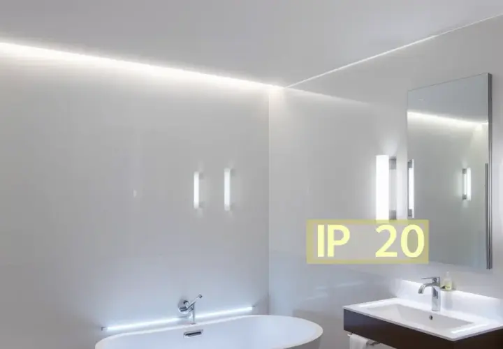 Salle de bain moderne avec baignoire, lavabo et miroir. L'éclairage subtil met en valeur le design épuré. Le texte "IP 20 signification" indique la protection contre les corps solides.