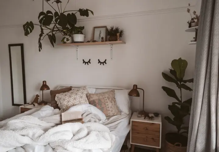 Lit, douillet et plein de verdure, ce lit invite à la détente. Une belle **déco chambre nature** avec des plantes luxuriantes et des coussins texturés.
