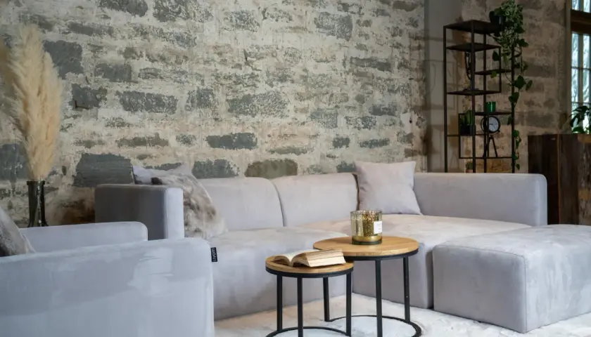Un salon cosy avec un canapé gris clair sur un tapis blanc. Une question se pose : quelle couleur de tapis irait le mieux avec un canapé gris ?