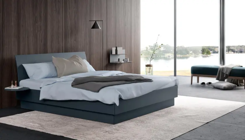 Une chambre grise moderne avec un grand lit, une vue sur l'eau et un mur en bois sombre.