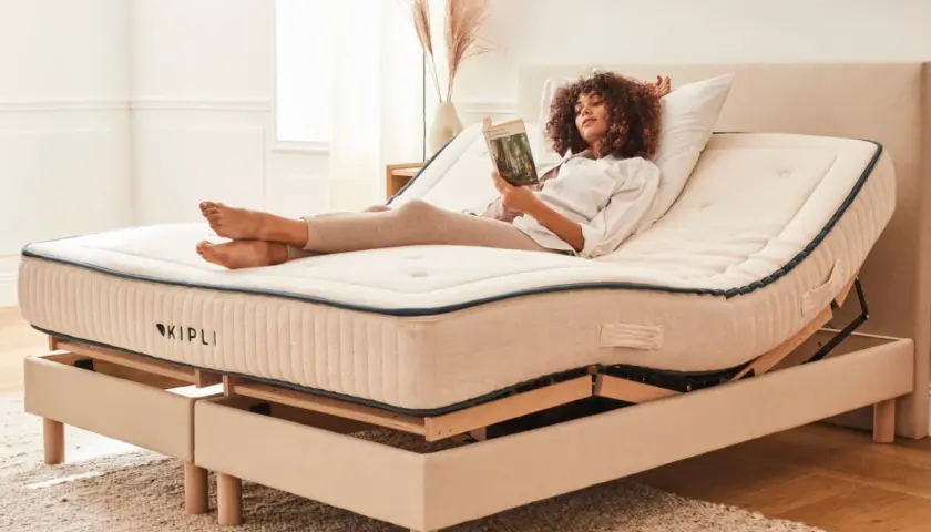 Femme lisant sur un lit électrique réglable. Avantage inconvénient lit électrique : confort personnalisé pour la détente.