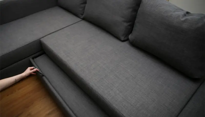 Maintenant, découvrez comment démonter un canapé relax. Une main tire sur une partie du siège pour commencer le désassemblage.