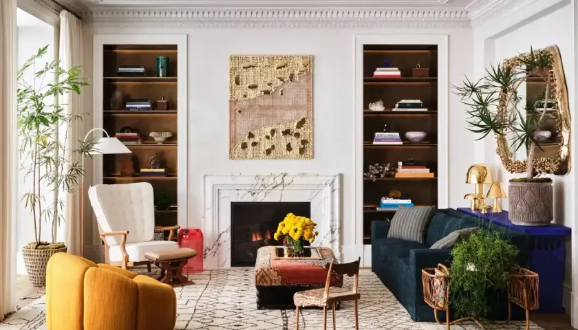 Un salon élégant où un **mixer moderne et ancien** se révèle dans le mobilier éclectique, les étagères remplies et l'art mural texturé.