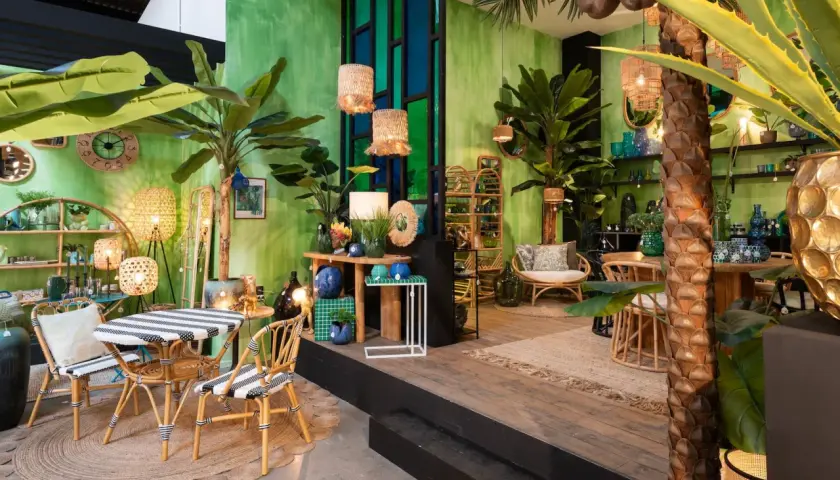 Un salon jungle chic avec des plantes luxuriantes, des meubles en rotin et des touches de bleu et d'or.