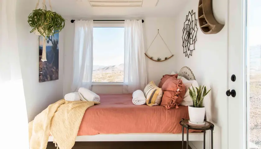 Une chambre d'amis polyvalente avec un lit confortable, des plantes vertes et une vue désertique.