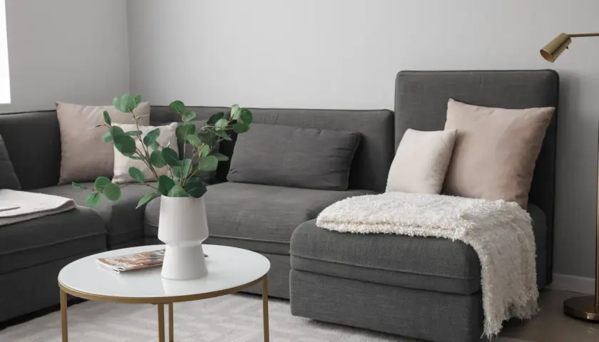 Comment disposer des coussins sur un canapé d'angle : des coussins roses et gris créent un look cosy.