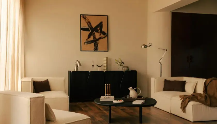 Salon moderne avec fauteuils blancs, buffet noir, tableau abstrait et table basse. Une ambiance chaleureuse pour une deco interieur tendance.