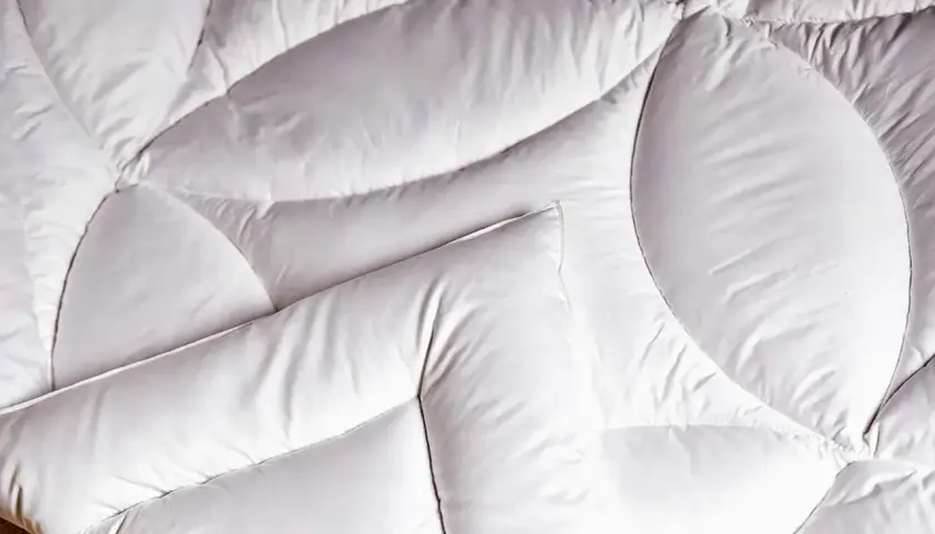 Un édredon blanc, doux et matelassé, prêt à vous envelopper de chaleur. C'est quoi un édredon ? C'est ce confort douillet.