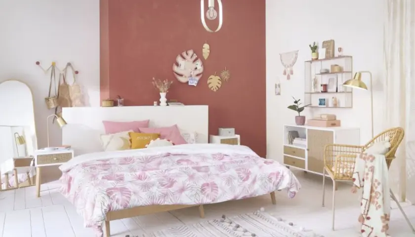 Chambre rose et vert adulte, avec un lit douillet, des touches végétales et une décoration murale tendance.