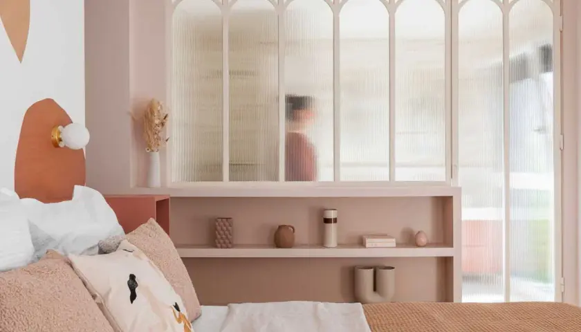 Idées pour comment décorer sa chambre : une chambre douce aux tons pastel, avec une tête de lit originale et des étagères décorées.