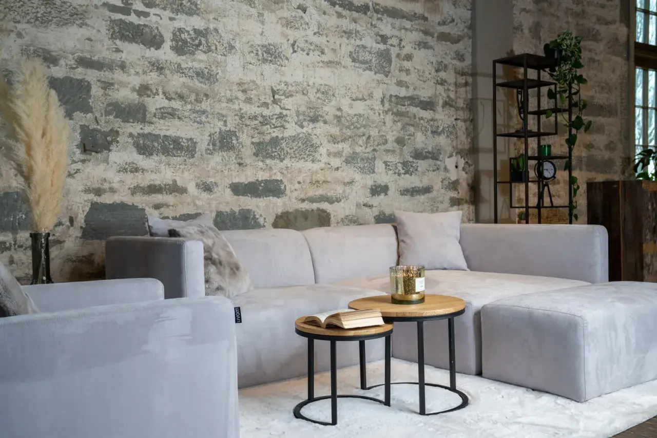 Un salon cosy avec un canapé gris clair sur un tapis blanc. Une question se pose : quelle couleur de tapis irait le mieux avec un canapé gris ?