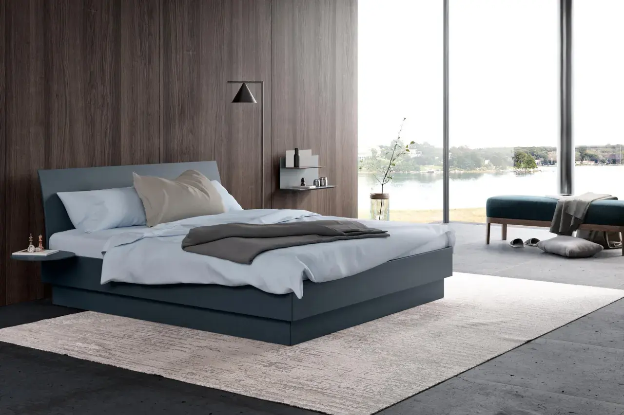 Une chambre grise moderne avec un grand lit, une vue sur l'eau et un mur en bois sombre.