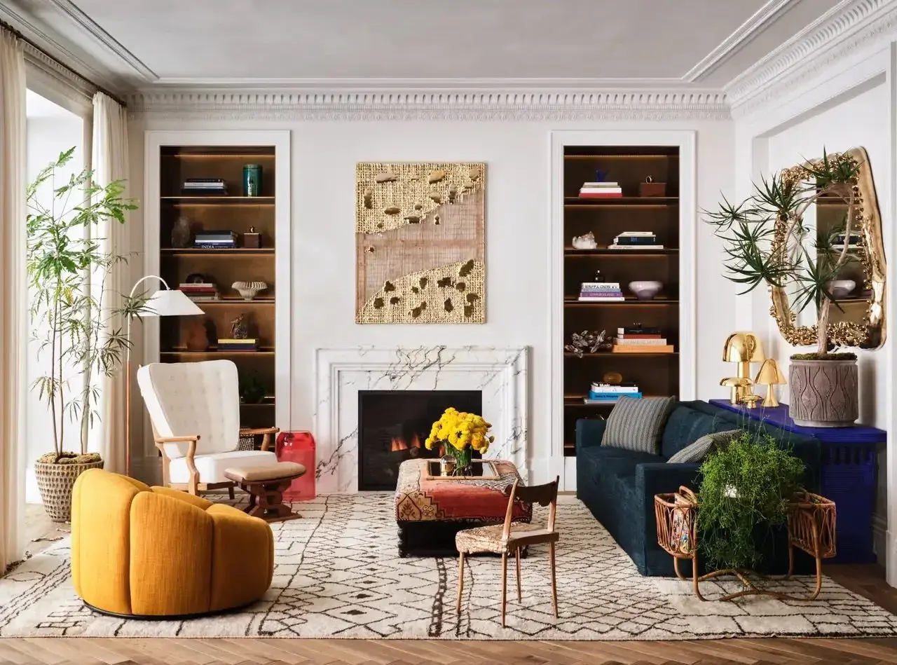 Un salon élégant où un **mixer moderne et ancien** se révèle dans le mobilier éclectique, les étagères remplies et l'art mural texturé.
